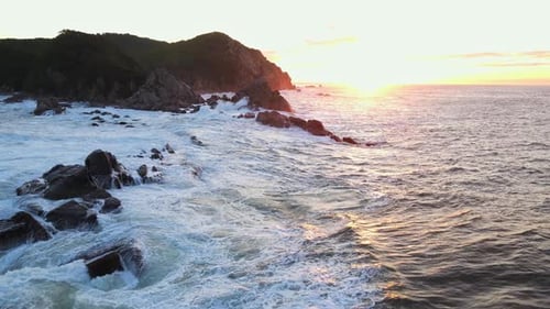 Raging Sea in the Morning at Dawn Waves Roll on the Rocky Shore Spray Soars Into the Sky