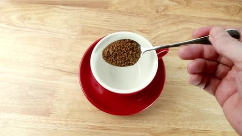 Close Up Teaspoon of Coffee Into a Red Mug Freezedried Coffee Dipped Into a Red Cup Coffee Granules