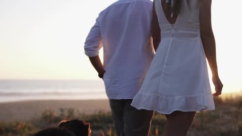 Couple Holding Hands at Beach During Sunrise