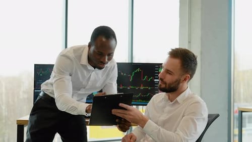 Deux traders de crypto-monnaies font une analyse professionnelle d'un graphique en chandeliers, créant une stratégie avec un stylo