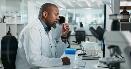 Scientist Typing at Computer in Bright Lab