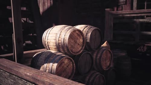 Wooden Barrels Stacked in Rustic Warehouse During Afternoon Sunlight