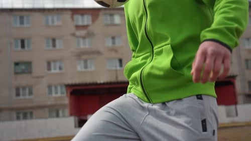 Young Man Performing Closerange Football Tricks Confidently Casual Street Performer Executing