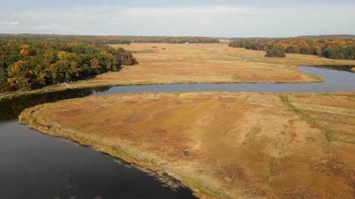 4K Static Drone Shot Over Plains, River, And Forest In The Fall