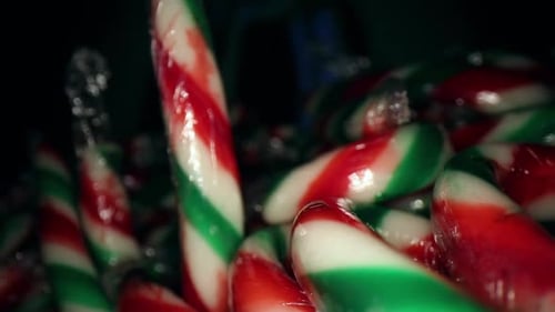 Ziehen Sie sich von einem Stapel eingewickelter roter, weißer, grüner Mini-Sonbonstangen ab Tolle Makroansicht der Dose