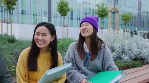 Young Trendy Asian Friends Having Fun Talking While Sitting at City Park