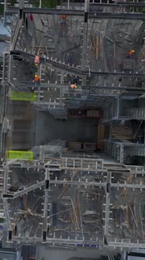 Vertical Video Aerial Perspective of Construction Workers Engaged in Various Activities With Tools