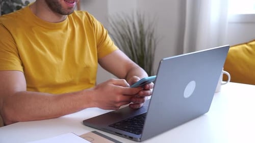 Young Adult Smiling Using Mobile Phone at Desk