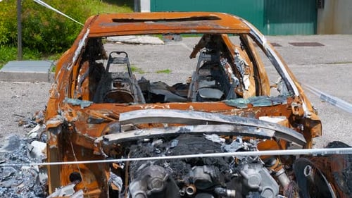 Burnt Out Car Wreckage in Suburban Setting