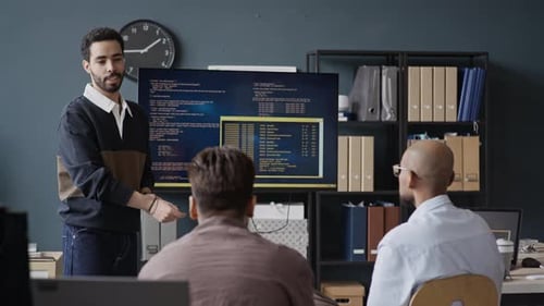 Junger Programmierer aus dem Nahen Osten präsentiert seinen Kollegen im IT-Büro Code