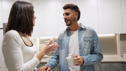 Young Couple Talking in Modern Kitchen at Breakfast