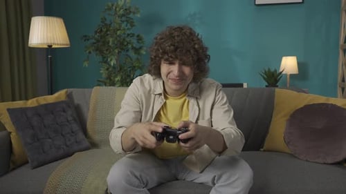 Excited Man Plays Video Game on Couch