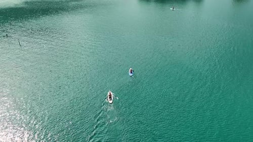Aerial View Paddleboarding Through a Vast Green Canyon Exploring and Enjoying Nature