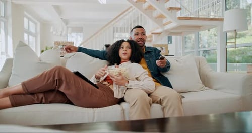Couple Relaxing on Couch, Watching TV, Eating Popcorn