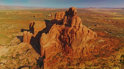 Unusual sunlit mount with rounded edges in the middle of desert. Panning footage of beautiful rock