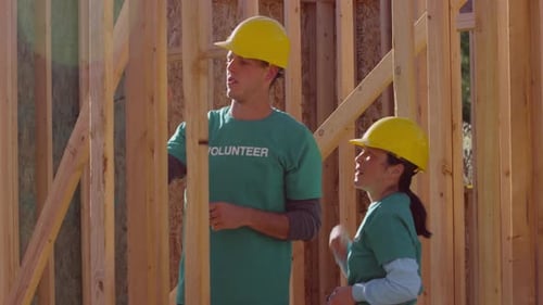 Volunteers Inspect Wood Framing on Construction Site