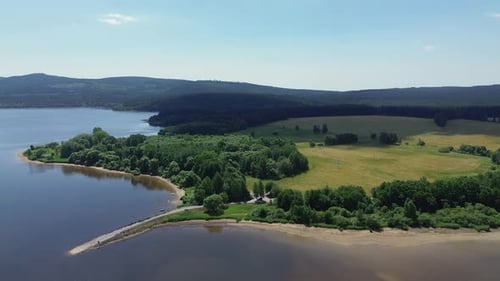 Filmmusik Blick von der Drohne, wie sie sich von oben über die Landschaft und auch über das große Blau dreht