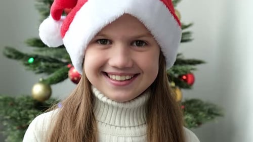 Smiling Girl Wearing a Santa Hat at Christmas