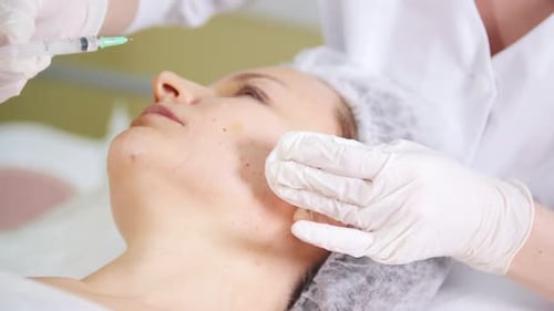 Kosmetikerin, die ein kosmetisches Verfahren zur Mesotherapie des Gesichts durchführt
