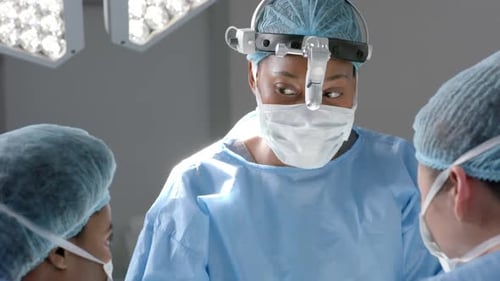 Diverse female surgeons operating on patient in operating theatre, slow motion