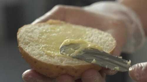 Spreading Butter on a Bun for a Sandwich