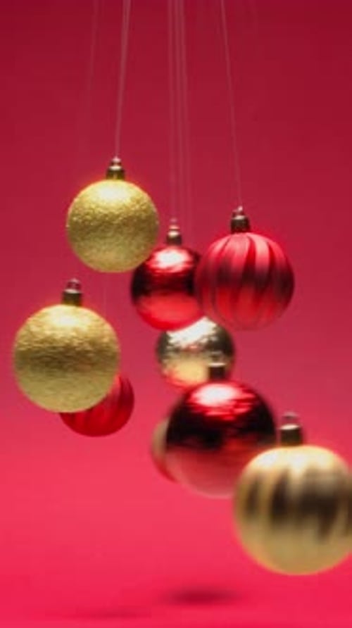 Pendulum of Hypnotic Christmas Ball Swinging in Front of Red Background