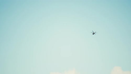 slow motion shot of a helicopter flying in the sky making a right hand turn