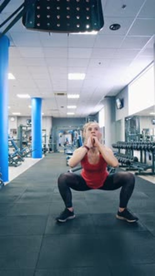 Sporty woman exercising in gym. Fit female doing intense training workout in gym