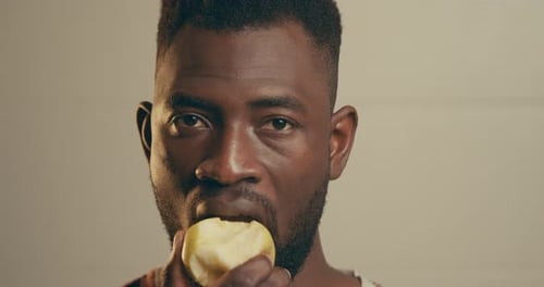 Young Adult Man Eating Apple Close Up
