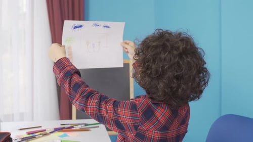The child draws a picture with colored pencils.