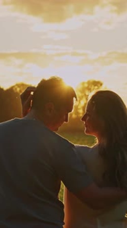 Couple Enjoys Sunset Together in Peaceful Field