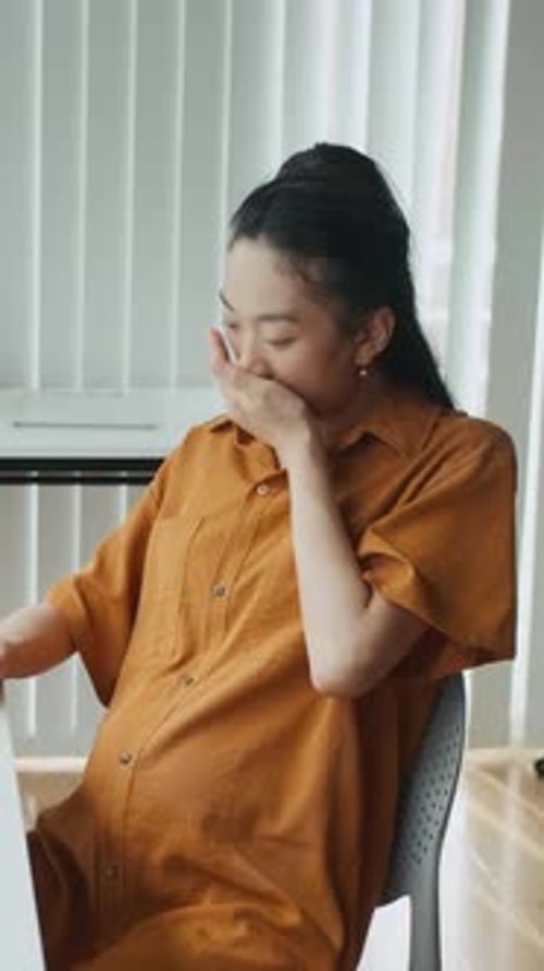 Expectant Mother Taking Vitamin at Office Desk Vertical