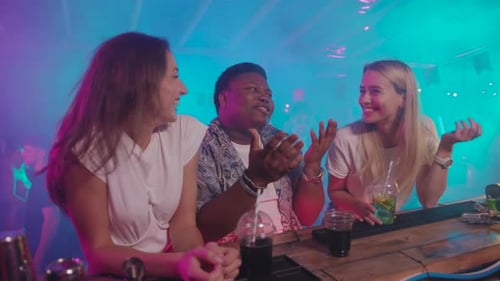 Friends are Enjoying a Lively and Funfilled Night Out Together at a Vibrant Bar Establishment