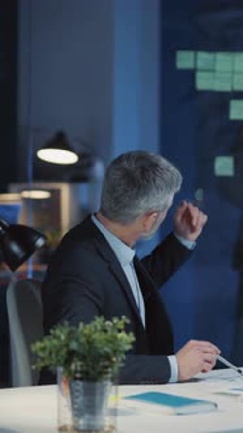 Businessman Analyzing Data Late at Night in Office