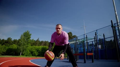 Athletic Player Perfecting Dribbling Skills on Outdoor Basketball Court in Slow Motion