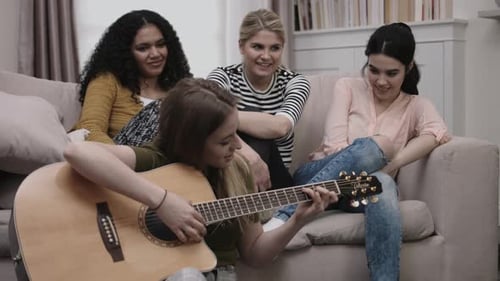Grupo de amigas toca violão na sala de estudantes