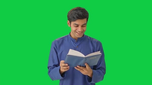 Happy Indian man reading a book Green screen