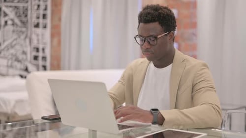 Young Adult Working on Laptop in Modern Interior