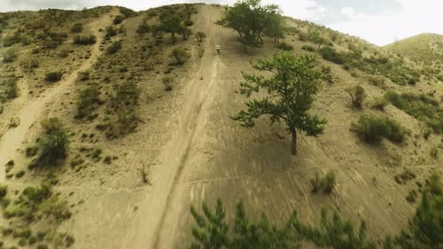 Dirt Bike Ascends Sandy Mountain in Aerial Shot