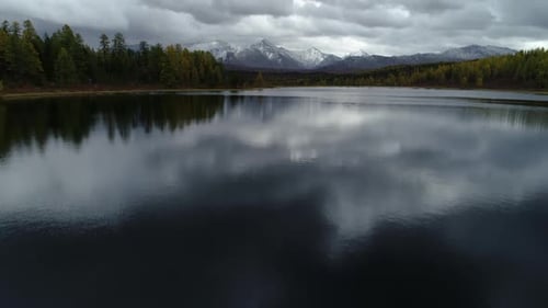 Bela floresta panorâmica brilhante no horizonte, montanhas nevadas, picos e lago