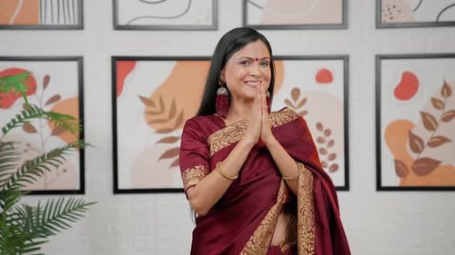Smiling Woman Claps in Traditional Saree Indoors