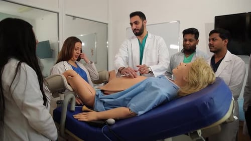 Professeurs et étudiants en obstétricien-gynécologue près d'un mannequin de femme enceinte