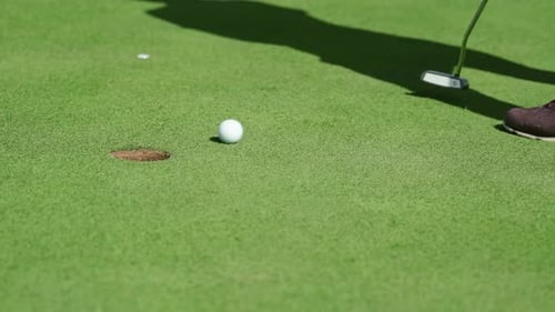 While Playing Golf a Girl Hits the Ball with a Club and It Hits the Hole