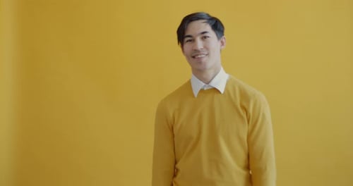 Young Adult Smiling and Giving Okay Sign