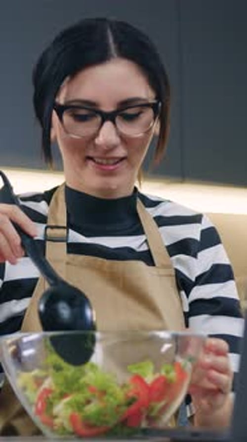Woman Making Salad with Vegetables in Kitchen