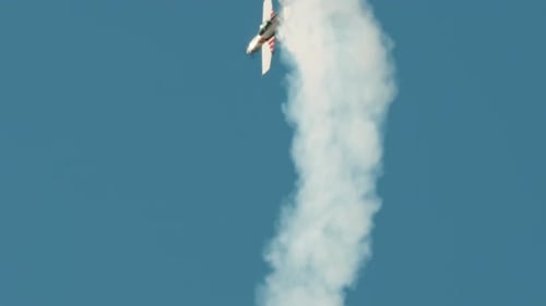 Aerobatics with Stunt Plane and White Smoke Trail