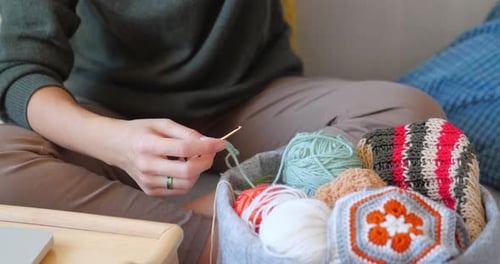Woman Crocheting Yarn with Hook at Home