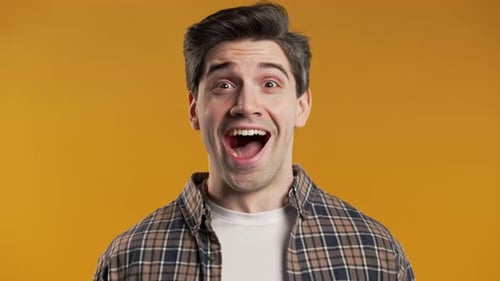 Excited Young Adult Smiling Broadly, Orange Background