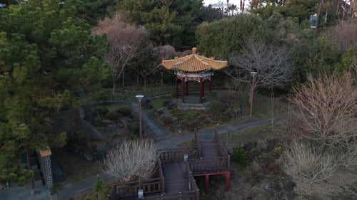 Drone aerial view in South Korea countryside lowering in front of a asian temple surrounded by green