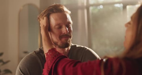 Affectionate Woman Touching Relaxed Man's Face Indoors